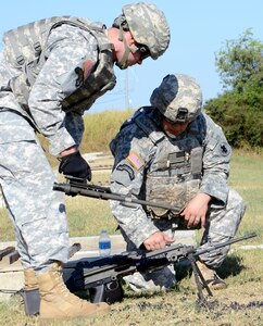 Staff Sgt. Ryan Campbell (left) and Sgt. Robert Pontius, U.S. Army South Headquarters Support Company, work at changing the barrel of an M249 machine gun at Camp Bullis Aug. 25.