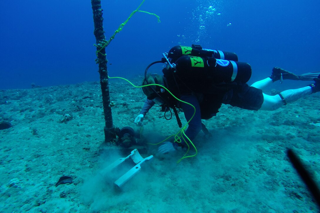 Navy Petty Officer 2nd Class Joseph Hophan verifies an anchor point in 110 feet of seawater to use during cable-splicing operations to allow a cable ship to anchor in Barking Sands, Hawaii, Aug. 23, 2015.  Hophan is assigned to Underwater Construction Team 2. U.S. Navy photo by Petty Officer 2nd Class Dave Madmon