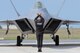 A crew chief with the Air Combat Command F-22 Raptor Demo Team taxis a Raptor onto the flightline at Atlantic City Air National Guard Base, N.J., Aug. 31, 2015. Two F-22s performed at the Atlantic City Airshow. (U.S. Air National Guard photo/Senior Airman Shane S. Karp)
