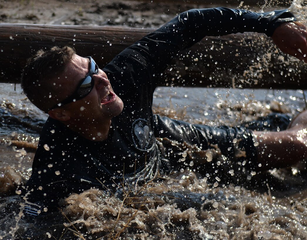Chief Master Sgt. Wayne Stott, the 90th Medical Group superintendent, splashes through muddy water Aug. 29, 2015, during the second annual mud run at F.E. Warren Air Force Base, Wyo. The run attracted more than 100 Airmen and their families. (U.S. Air Force photo/Airman 1st Class Brandon Valle)