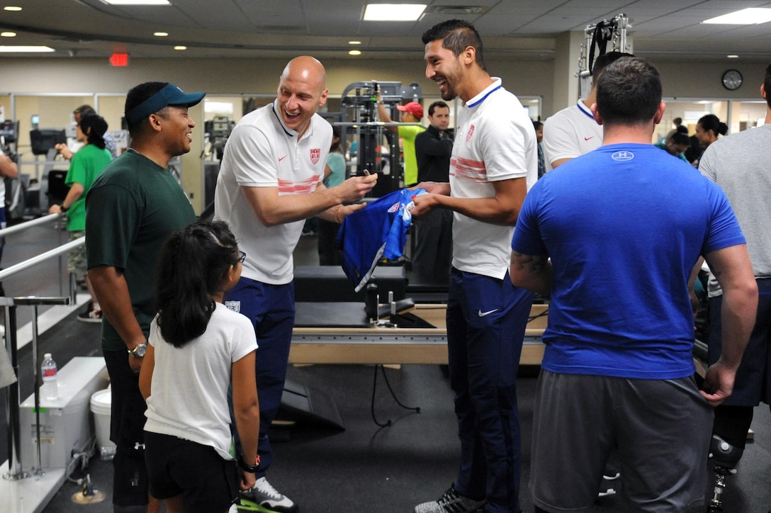 U.S. Men's National Team members Brad Guzan, left, and Omar Gonzalez sign autographs for 8-year-old Lexi Terry, the daughter of Jae Terry, during an event with the soccer team and wounded warriors at Walter Reed National Medical Center in Bethesda, Md., Sept. 3, 2015. DoD photo by Marvin Lynchard