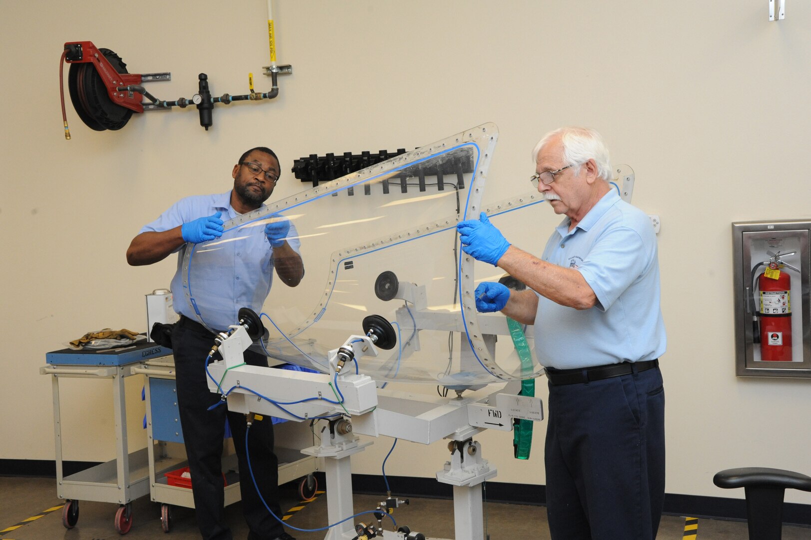 Donnell Leigh, (left) and Michael LoBue, 12th Flying Training Wing egress technicians, replace the detonation cord on a canopy of a T-6 Texan aircraft during the aircraft's phase maintenance inspection Aug. 17, 2015, at Joint Base San Antonio-Randolph.   To ensure aircraft remain in operational 12th FTW maintenance personnel conduct phase maintenance is the aircraft is in working order.  