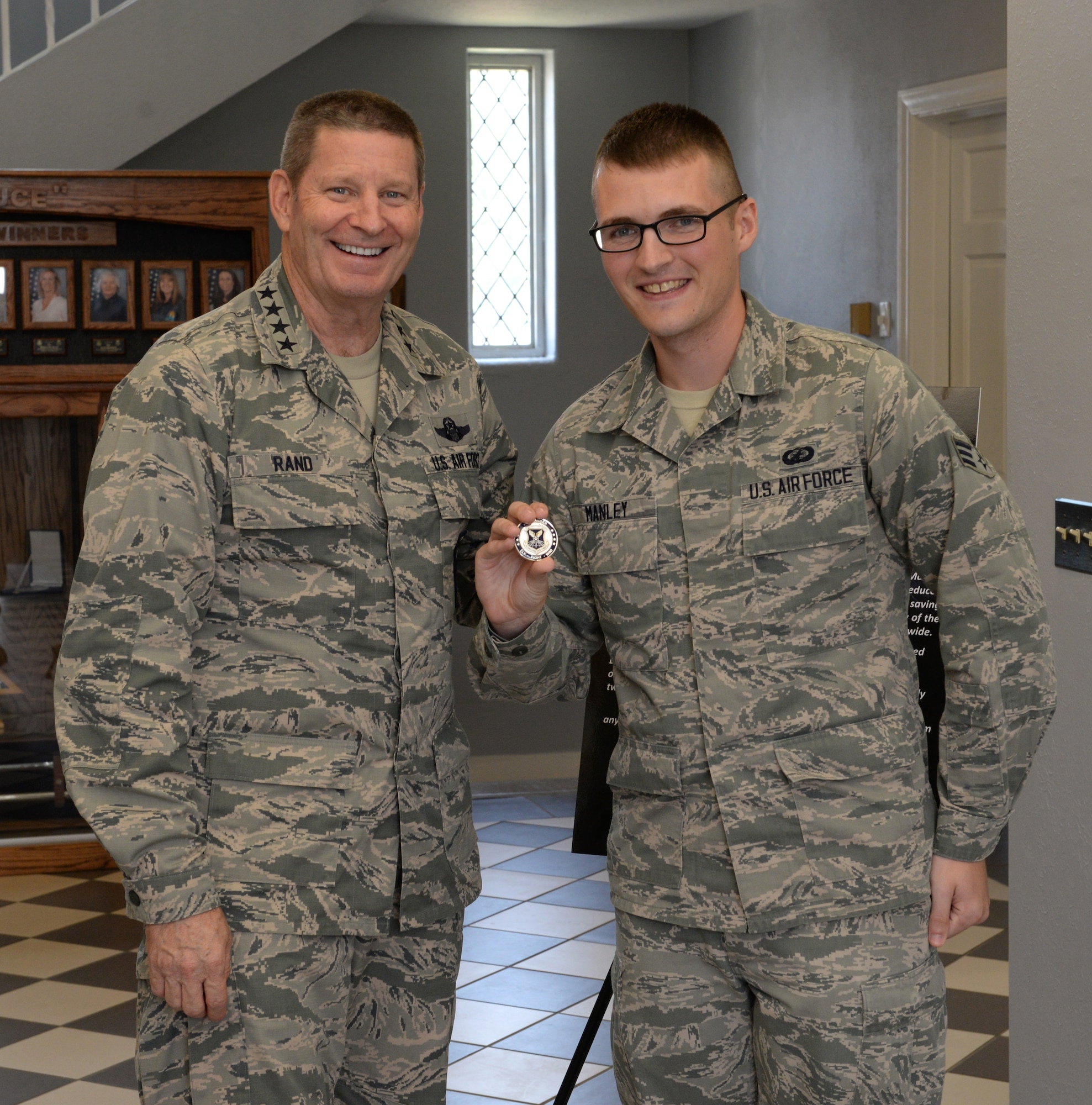 Gen. Robin Rand, Air Force Global Strike Command commander, and Senior Airman Jesse Manley, 2nd Comptroller Squadron budget analyst, pose for a photo after a coining at Barksdale Air Force Base, La., Aug. 27, 2015. While working with the Defense Enterprise and Accounting Management System, a manual data entry program, Manley created a new procedure which reduced a time-consuming process from three days to a mere 20 minutes. His time-saving approach is being adopted service-wide. (U.S. Air Force photo/Airman 1st Class Curt Beach)