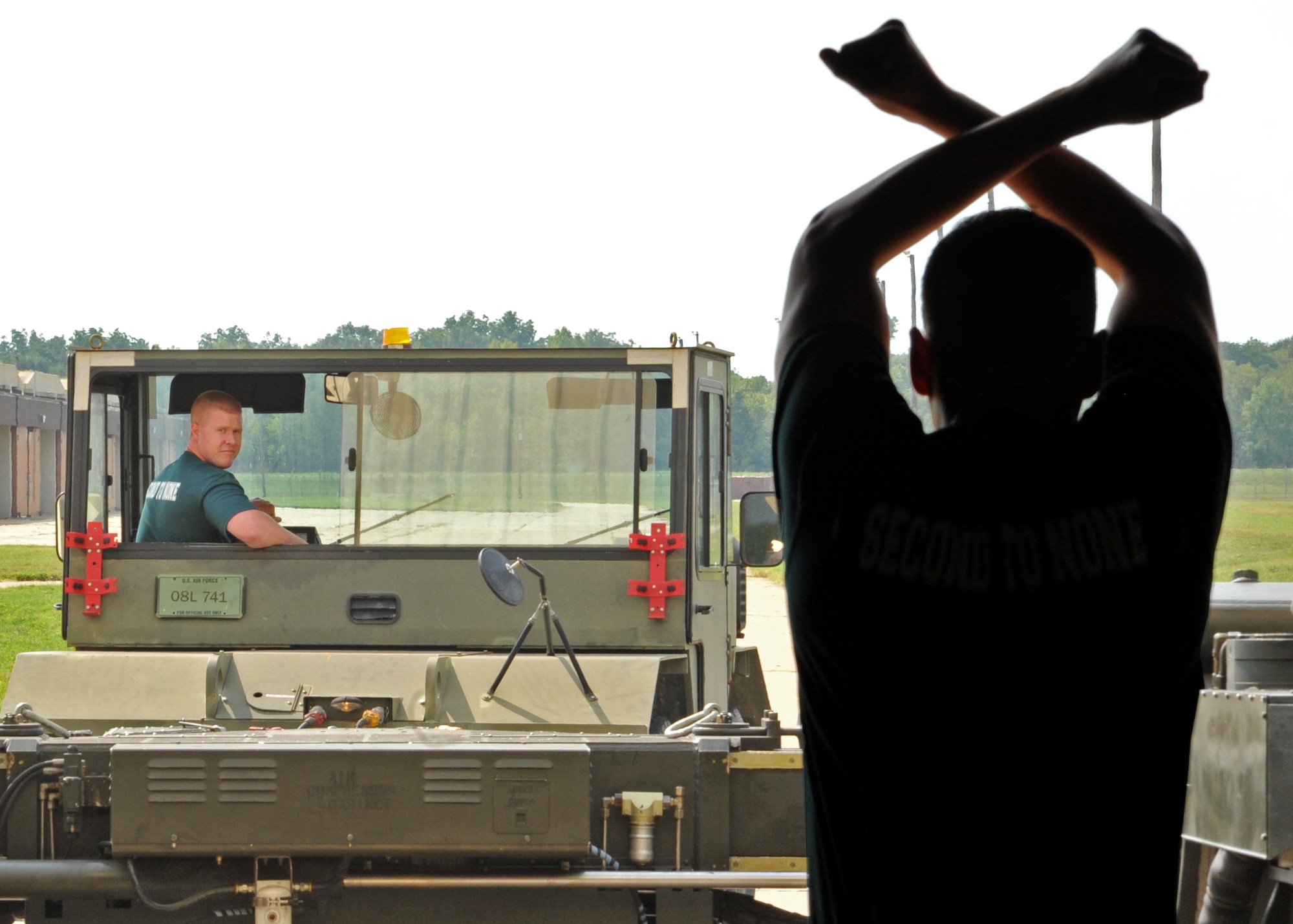 Senior Airman Joe Travers, 2nd Munitions Squadron nuclear maintenance team member, reads hand signals from a teammate during the weapons transport competition portion of the 2015 Global Strike Challenge at Barksdale Air Force Base, La., Aug. 31. The timed competition consisted of Airmen driving a Material Handling Unit-196 and backing it into a loading bay. (U.S. Air Force photo/Senior Airman Joseph Raatz)