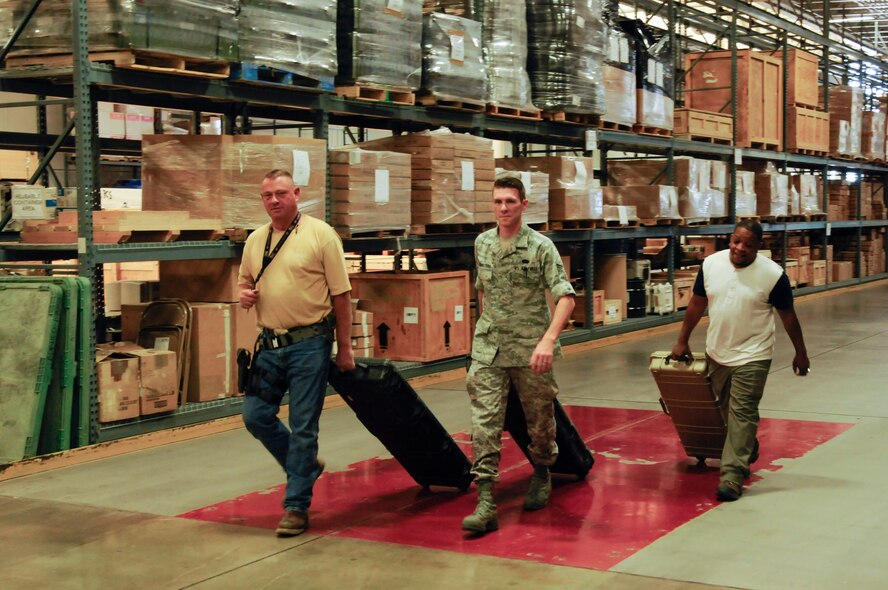 Brian Alexander, 90th Logistics Readiness Squadron materials handler; Senior Airman Andrew Leemasters, 90th LRS non-commissioned officer in charge of individual protection equipment; and Derrick McFadden, 90th LRS do-in-for maintenance monitor, roll cases with weapons to store in the armory of the 90th LRS Warehouse on F.E. Warren Air Force Base, Wyo., Sept. 2, 2015. The logistics Airmen placed the weapons in a secure storage unit for safekeeping until the weapons are needed again. (U.S. Air Force photo by Senior Airman Jason Wiese)