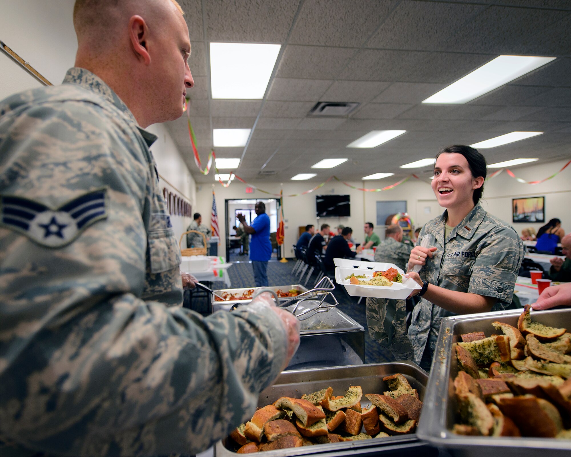 2nd Lt. Jessica Franklin grabs a plate of food at the August SIGMO at Vance Air Force Base, Oklahoma, Aug. 31. SIGMOs, or Single International Gourmet Meal Opportunities, are monthly meals sponsored by the Base Chapel and hosted by wing units to promote a sense of community across the base. (U.S. Air Force photo / David Poe)