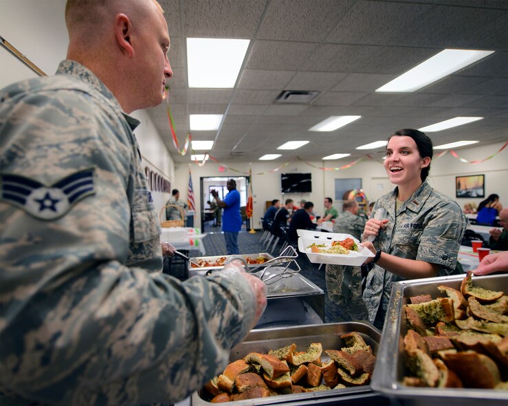 2nd Lt. Jessica Franklin grabs a plate of food at the August SIGMO at Vance Air Force Base, Oklahoma, Aug. 31. SIGMOs, or Single International Gourmet Meal Opportunities, are monthly meals sponsored by the Base Chapel and hosted by wing units to promote a sense of community across the base. (U.S. Air Force photo / David Poe)