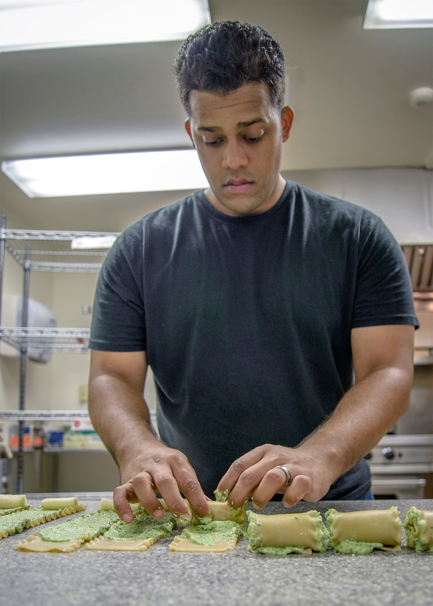 Tech. Sgt. Manuel Feliz rolls spinach, ricotta pinwheels at Vance Air Force Base, Oklahoma, Aug. 31. The 71st Operations Support Squadron hosted the August Single International Gourmet Meal Opportunity, which is a monthly meal sponsored by the Base Chapel. (U.S. Air Force photo / David Poe)