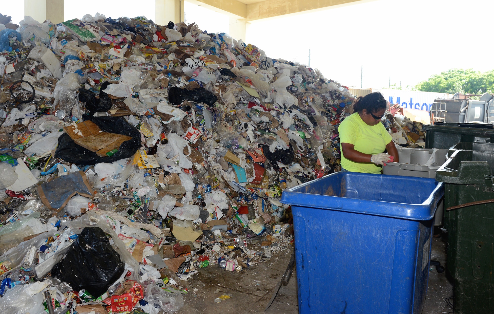 Jessica Dabinon, Arc Light Recycling Center refuse collector, separates recyclable material from a pile Aug. 28, 2015, at Andersen Air Force Base, Guam. The Arc Light Recycling Center’s goal is to divert as much material out of the waste stream as possible. (U.S. Air Force photo by Airman 1st Class Arielle Vasquez/Released)