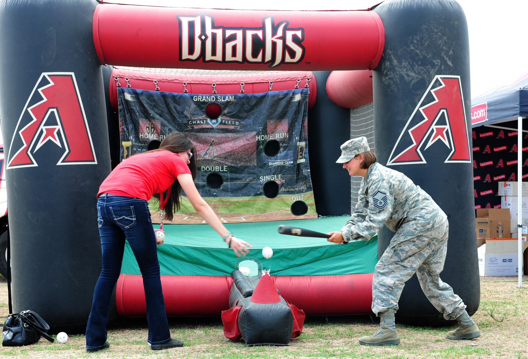 U.S. Air Force Master Sgt. Chandra Barlow, 14th Reconnaissance Group NCO in charge of command support staff, plays T-ball with an Arizona Diamondback street team member during a “Welcome Home” barbecue at Davis-Monthan Air Force Base Ariz., Sept. 3, 2015. The event was held by the Tucson community to show its appreciation towards the Airmen of D-M for all the work they have done during this past deployment cycle.  (U.S. Air Force photo by Airmen 1st Class Cheyenne A. Powers/Released) 