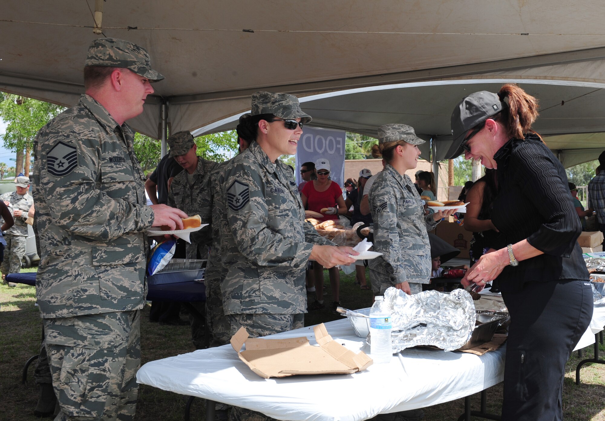 Airmen are served food during a “Welcome Home” barbecue at Davis-Monthan Air Force Base Ariz., Sept. 3, 2015. The Tucson community provided hamburgers, hotdogs, drinks, as well as entertainment for the D-M Airmen. (U.S. Air Force photo by Airmen 1st Class Cheyenne A. Powers/Released)