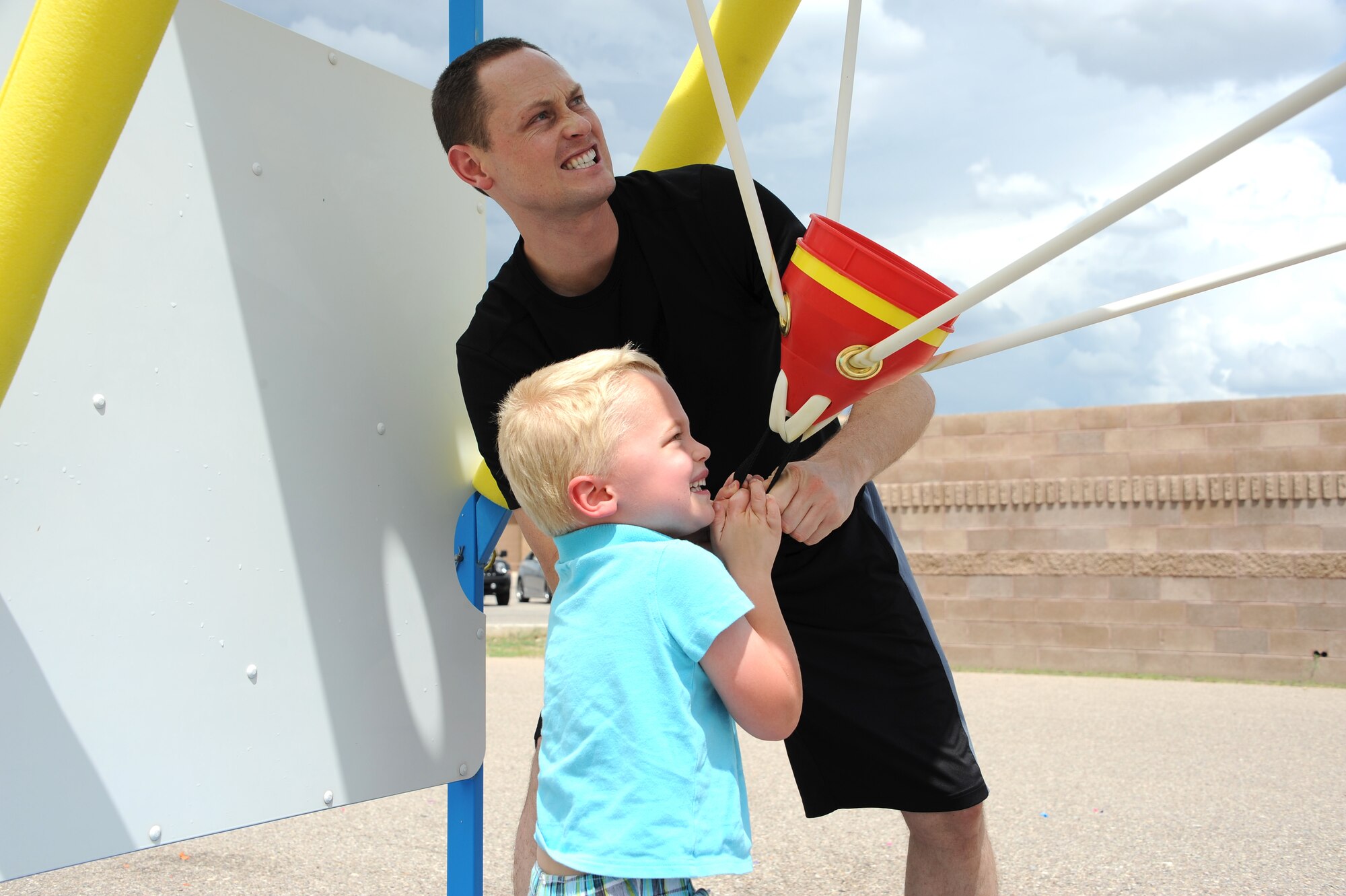 U.S. Air Force 1st Lt. Corbin Lind, 355th Operations Group executive officer, and his son prepare to launch water-balloons in a water war Sept. 3, 2015, during a “Welcome Home” barbecue at Davis-Monthan Air Force Base, Ariz.  The Tucson community provided activities ranging from water wars, paintball, live music and more for returning deployers and their families. (U.S. Air Force photo by Airman 1st Class Ashley Steffen/Released)