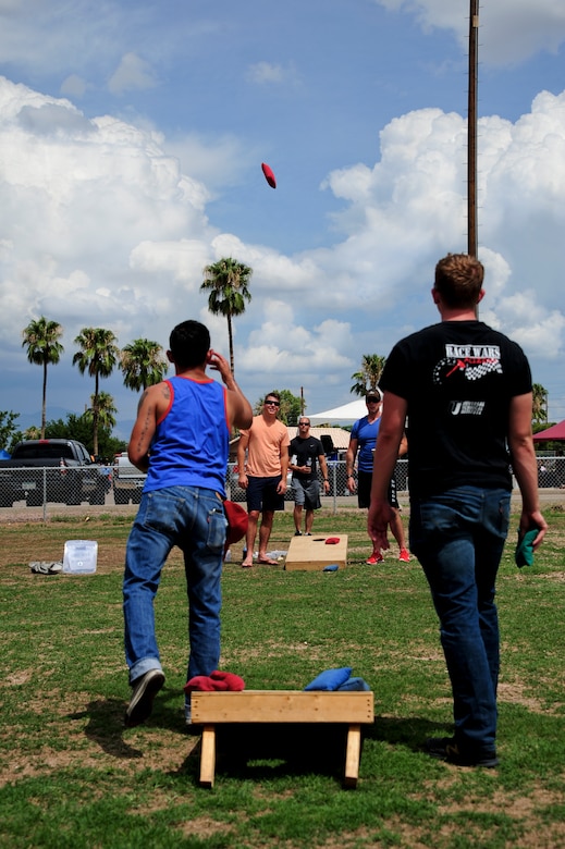 U.S. Air Force Desert Lightning Team Airmen play cornhole at Bama Park during the “Welcome Home” barbecue at Davis-Monthan Air Force Base, Ariz., Sept. 3, 2015. The event was hosted by the Tucson community to show its appreciation for D-M’s servicemen and servicewomen who returned from the base’s largest deployment since World War II. (U.S. Air Force photo by Airman 1st Class Chris Drzazgowski/Released)