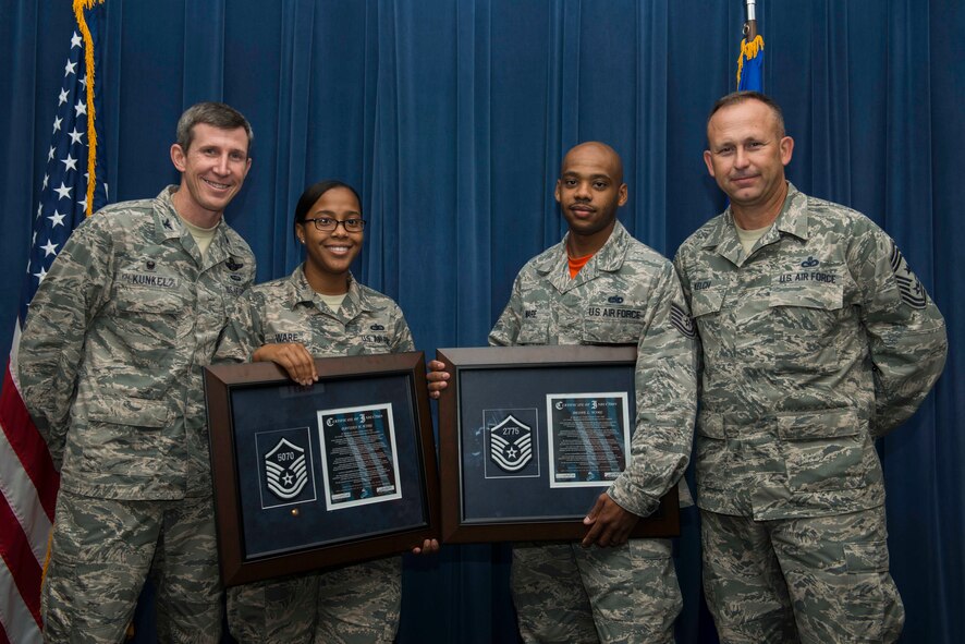 U.S. Air Force Tech. Sgts. Davisha Ware (middle left), 23d Mission Support Group NCO in charge of command administration, and Deone Ware (middle right), 23d Operations Support Squadron section chief, pose for a photo with 23d Wing leadership during a senior NCO memento ceremony Aug. 28, 2015, at Moody Air Force Base, Ga. The Wares, who have been married for eight years, were selected for promotion to the highest enlisted tier during the same cycle. (U.S. Air Force photo by Airman 1st Class Dillian Bamman/Released)