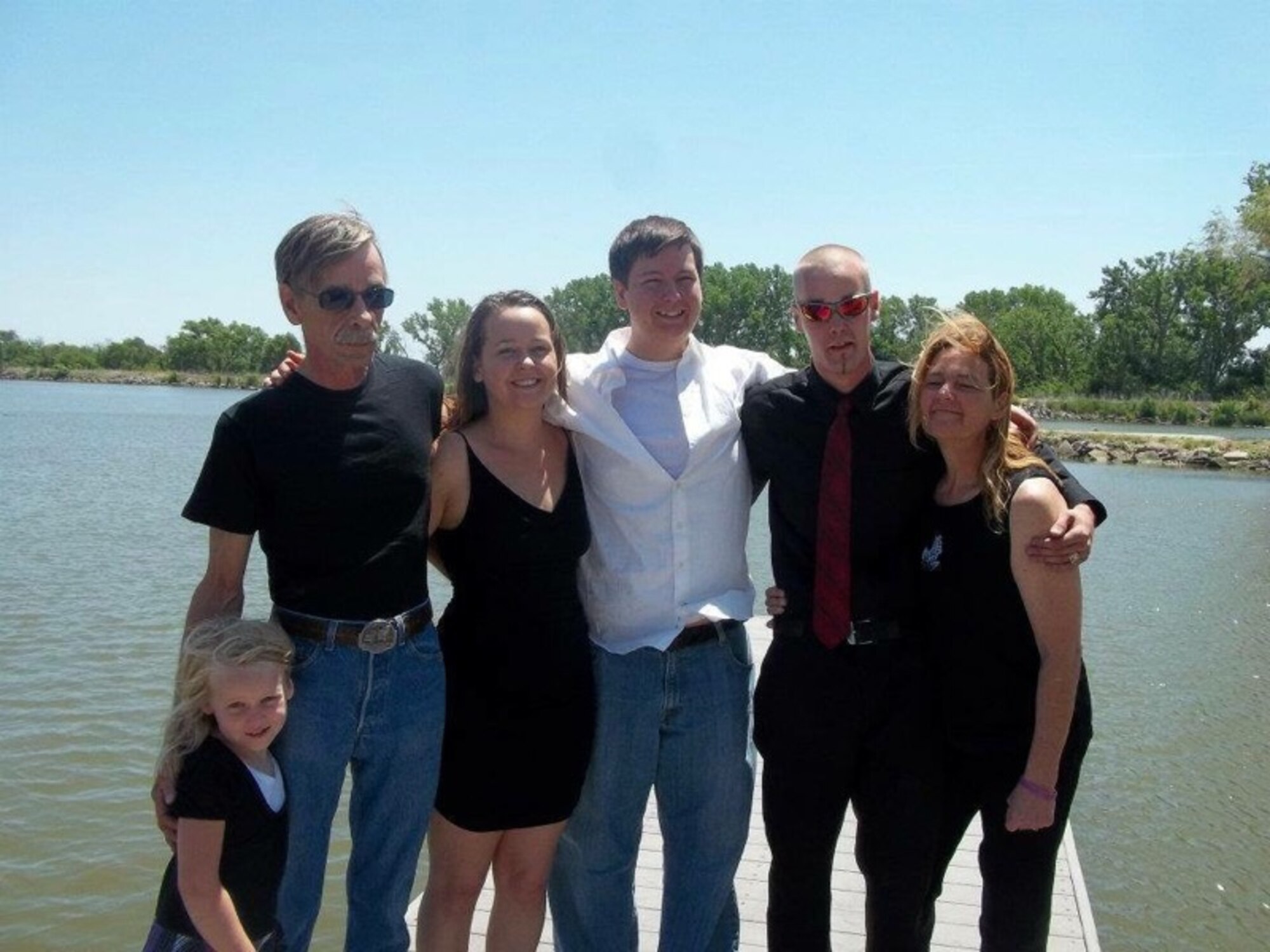 U.S. Air Force Airman 1st Class Daniel Meyer, 55th Aircraft Maintenance Squadron, stands in the center of his family for a photo after losing a significant amount of weight in order to reach his goal of joining the United States Air Force.  His father passed away from cancer not long after the photo was taken. (Courtesy photo) 