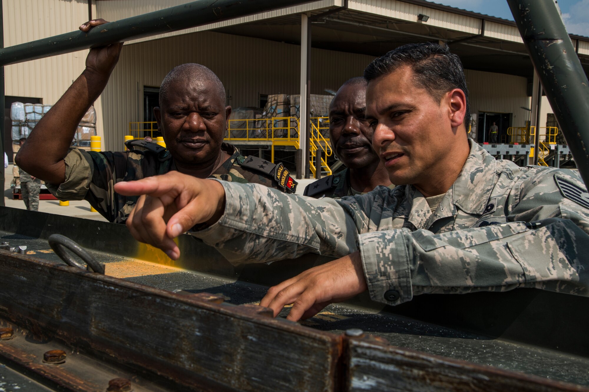 Tech. Sgt. Manuel Chavez, right, an air advisor assigned to the 818th Mobility Support Advisory Squadron, shares knowledge about the Halvorsen K Loader to members of the Angolan Air Force during the African Partnership Flight hosted by the 621st Contingency Response Wing at Joint Base McGuire-Dix-Lakehurst, N.J., Sept. 1, 2015. The African Partnership Flight program, sponsored and developed by U.S. Air Forces in Europe and Air Forces Africa, is the premier security cooperation program that partners U.S. and African personnel to improve professional military aviation knowledge, skills and cooperation. (U.S. Air Force photo by Staff Sgt. Gustavo Gonzalez)