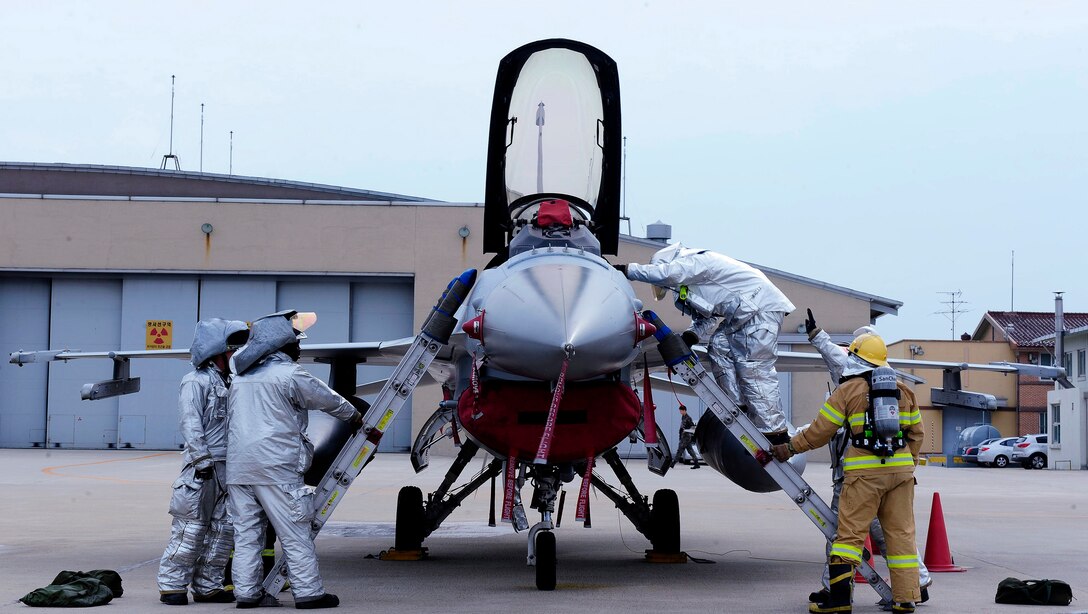 U.S. Air Force and Republic of Korea air force firefighters simulate egressing a pilot from an aircraft fire at Kunsan Air Base, Republic of Korea, Aug. 19, 2015. Firefighters from the 8th Civil Engineer Squadron train with ROKAF firefighters in various fire rescue techniques. (U.S. Air Force photo by Staff Sgt. Nick Wilson/Released)