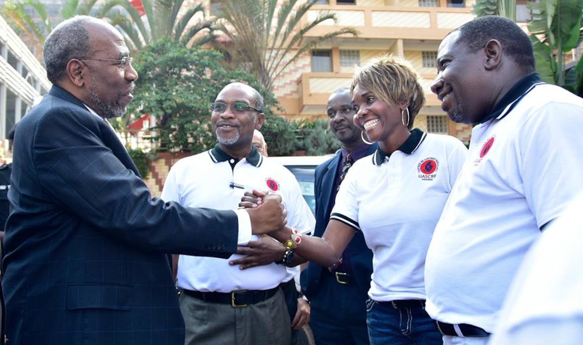 Maj. Lukiah Lucky Mulumba, second from right, 60th Inpatient Squadron intensive care nurse at Travis Air Force Base, Calif., shakes hands with Uganda Minister of Health Dr. Elioda Tumwesigye, in June. Mulumba's fight against sickle-cell disease, inspired by her daughter, Carol, has led to Ugandan leaders calling for a national policy to provide better education and treatment against the disease. (Courtesy photo)