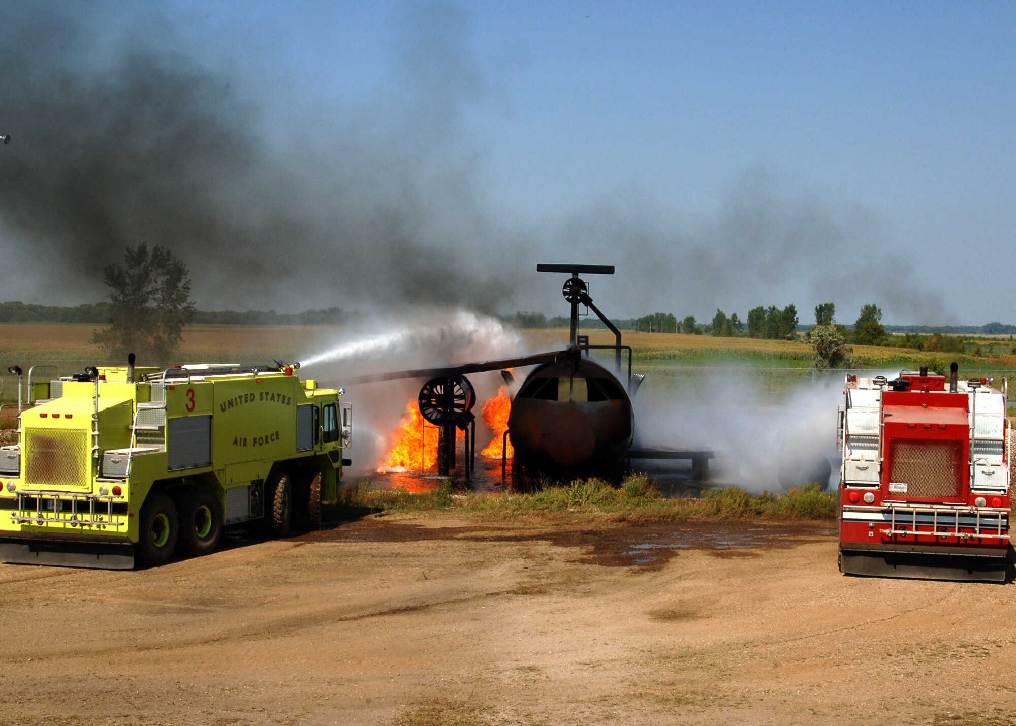 U.S. Air Force fire trucks extinguish a fire during a training exercise Sept. 2, 2015, on Grand Forks Air Force Base, North Dakota. Members of the Grand Forks Fire Department were working with the Grand Forks AFB Fire Department to learn aircraft firefighting techniques. Each truck was responsible for covering a specific side of the aircraft. (U.S. Air Force photo by Airman 1st Class Ryan Sparks/Released)