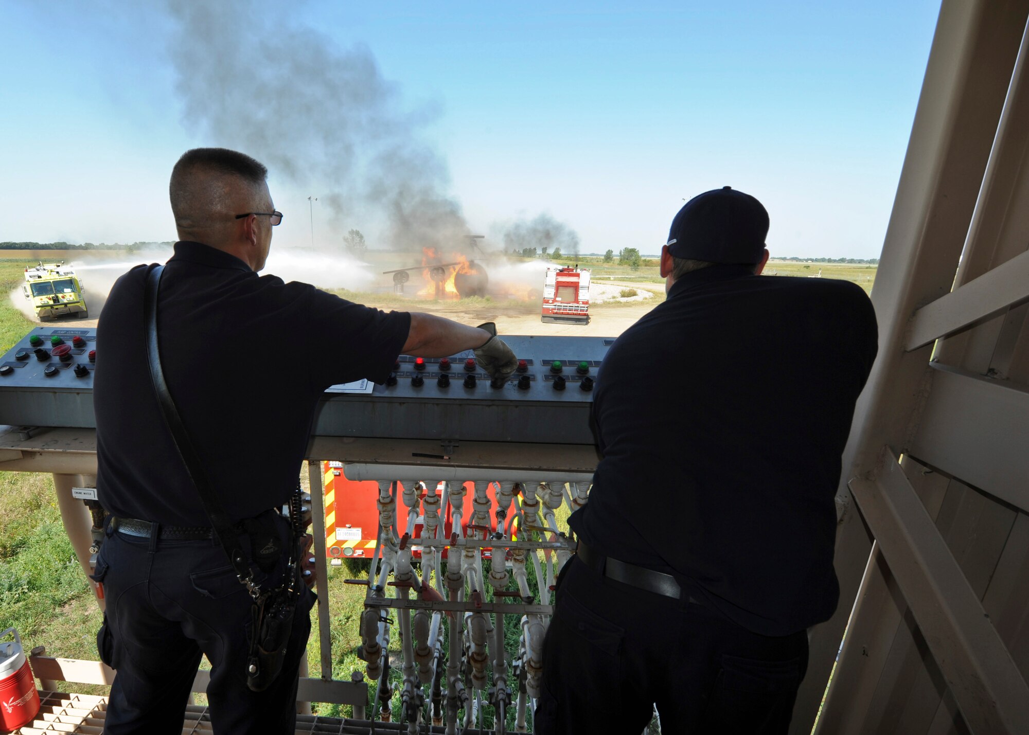 319th Civil Engineer Squadron lead firefighters James Mozey, left, and Jason Scribner, right, control the fire output during a training exercise Sept. 2, 2015, on Grand Forks Air Force Base, North Dakota. Mozey and Scribner were responsible for supplying the gas and igniting the fire for the joint exercise between the Grand Forks Fire Department and Grand Forks AFB Fire Department. Once proper firefighting techniques were demonstrated they were able to stop the fuel supply to the fire. (U.S. Air Force photo by Airman 1st Class Ryan Sparks/Released)