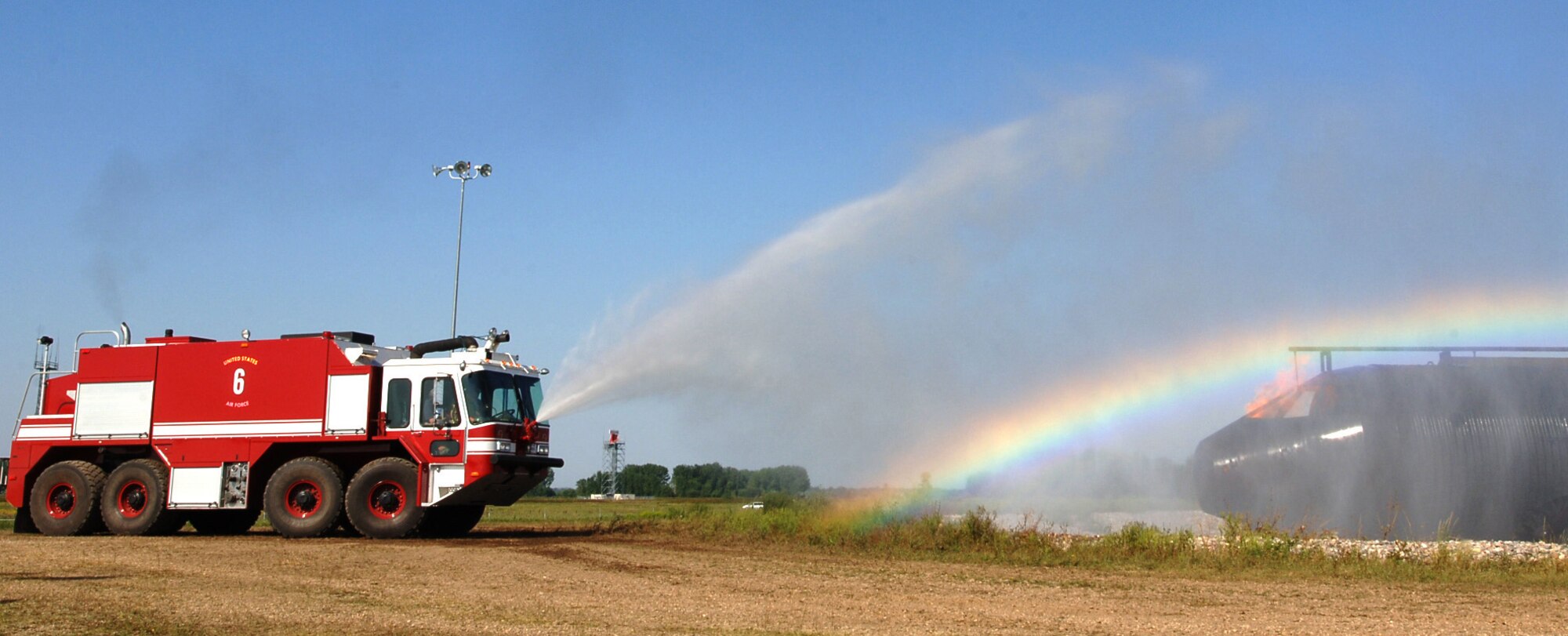 A U.S. Air Force fire truck douses a training aircraft during a live fire exercise Sept. 1, 2015, on Grand Forks Air Force Base, North Dakota. Members of the Grand Forks Fire Department joined the Grand Forks AFB Fire Department to learn tactics for fighting aircraft fires. (U.S. Air Force photo by Airman 1st Class Ryan Sparks/Released)