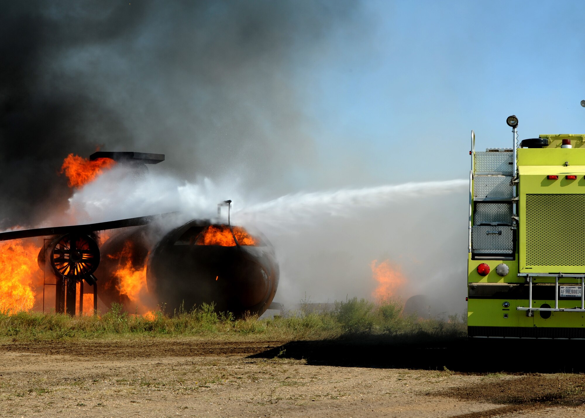 A U.S. Air Force fire truck extinguishes a fire during an aircraft fire training exercise Sept. 1, 2015, on Grand Forks Air Force Base, North Dakota. The hose was operated by a member of the Grand Forks Fire Department. They participated in the joint exercise to learn tactics for fighting aircraft fires. (U.S. Air Force photo by Airman 1st Class Ryan Sparks/Released)
