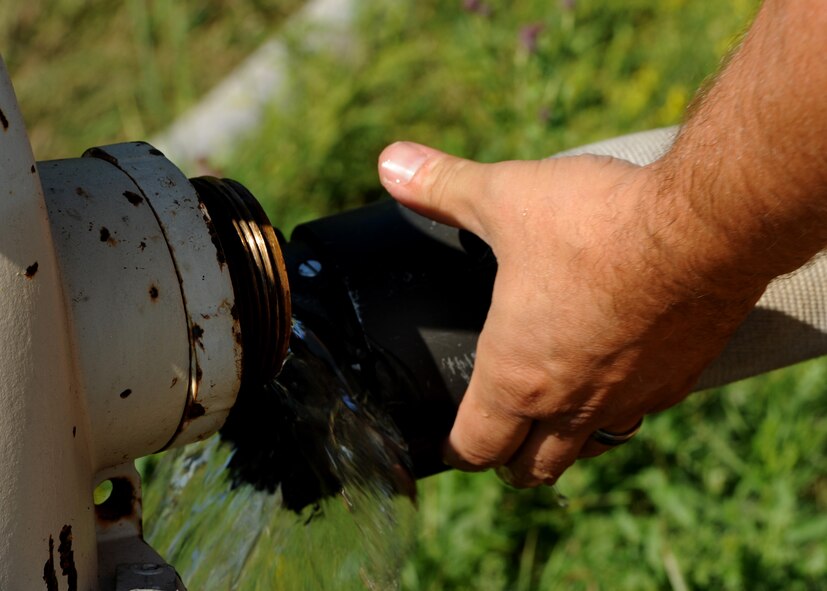 A member of the Grand Forks Fire Department removes a hose from a fire hydrant Sept. 1, 2015, on Grand Forks Air Force Base, North Dakota. The GFFD were participating in a live fire training exercise with the Grand Forks AFB Fire Department. Joint training allows the GFFD to learn tactics for fighting aircraft fires. (U.S. Air Force photo by Airman 1st Class Ryan Sparks/Released)