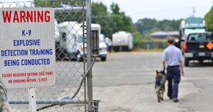 Cody Morris, Explosive Countermeasures International explosives canine handler, walks Orion, explosives detection dog, to a detection training site at Fort Eustis, Va., Aug. 31, 2015. The canines and handlers went through several detection sites where they were trained to find simulated explosive threats during a week-long certification course. (U.S. Air Force photo by Staff Sgt. Natasha Stannard/Released)