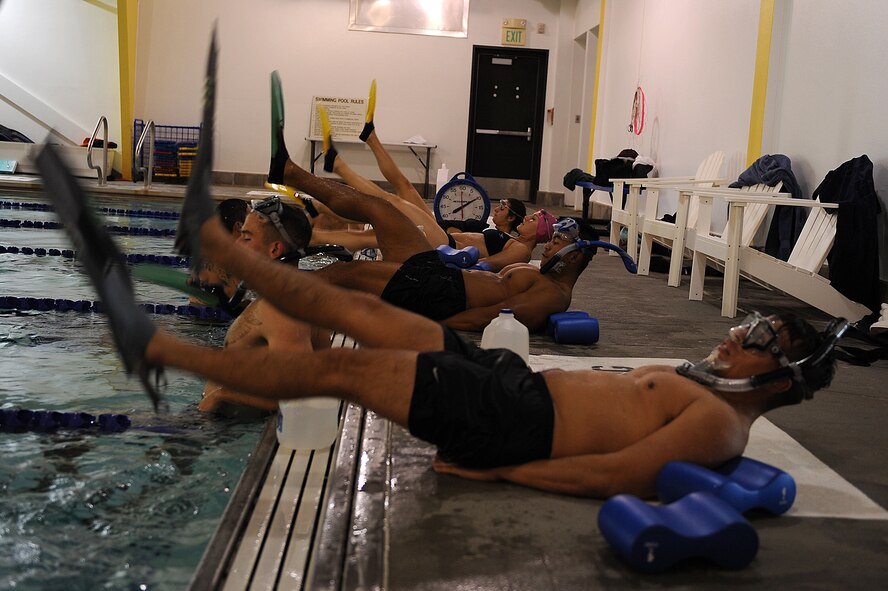 Members from the 91st Security Forces Group Global Strike Challenge team perform flutter kicks after swimming laps at Minot Air Force Base, N.D., Sept. 1, 2015. To train for the GSC, the team has been doing physical and mental training every day, as well as working on their tactics and teamwork. (U.S. Air Force photo / Senior Airman Kristoffer Kaubisch)
