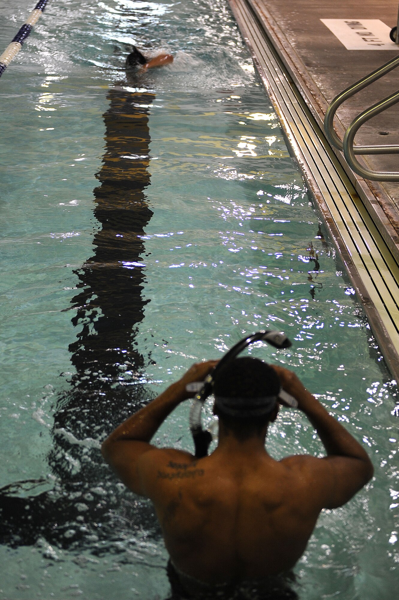 Airman 1st Class Andreas Wiggins, 91st Security Forces Group Global Strike Challenge team, prepares to swim a lap at Minot Air Force Base, N.D., Sept. 1, 2015. To train for the GSC, the team has been doing physical and mental training every day, as well as working on their tactics and teamwork. (U.S. Air Force photo / Senior Airman Kristoffer Kaubisch)