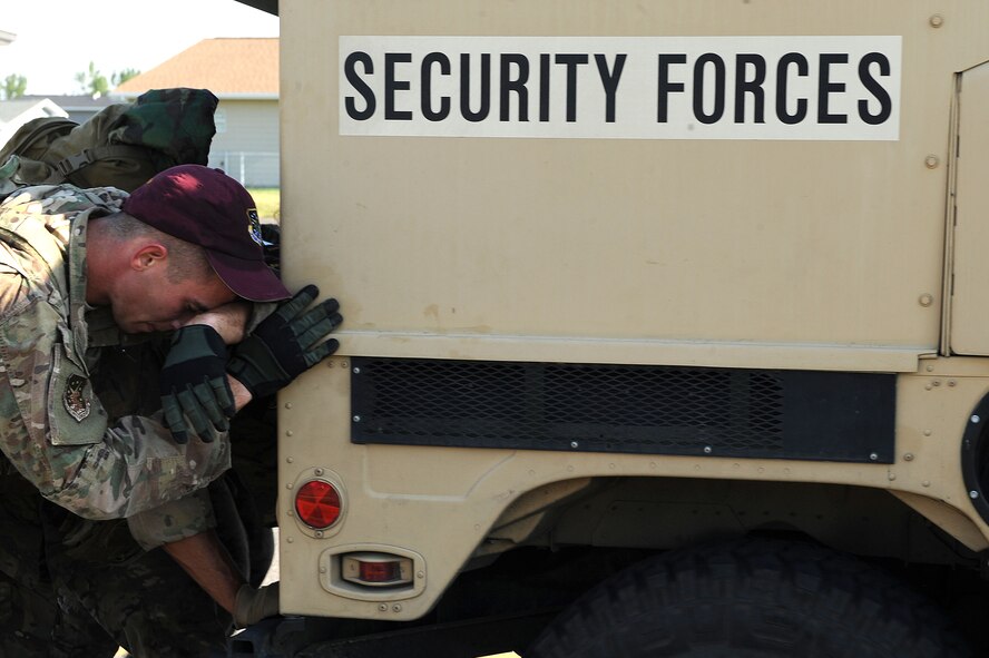 Senior Airman Brandon Weese, 91st Security Force Group Global Strike Challenge team, wipes sweat from his forehead while pushing a Humvee with his team at Minot Air Force Base, N.D., Sept. 1, 2015. To train for the GSC, the team has been doing physical and mental training every day, as well as working on their tactics and teamwork. (U.S. Air Force photo / Senior Airman Kristoffer Kaubisch)