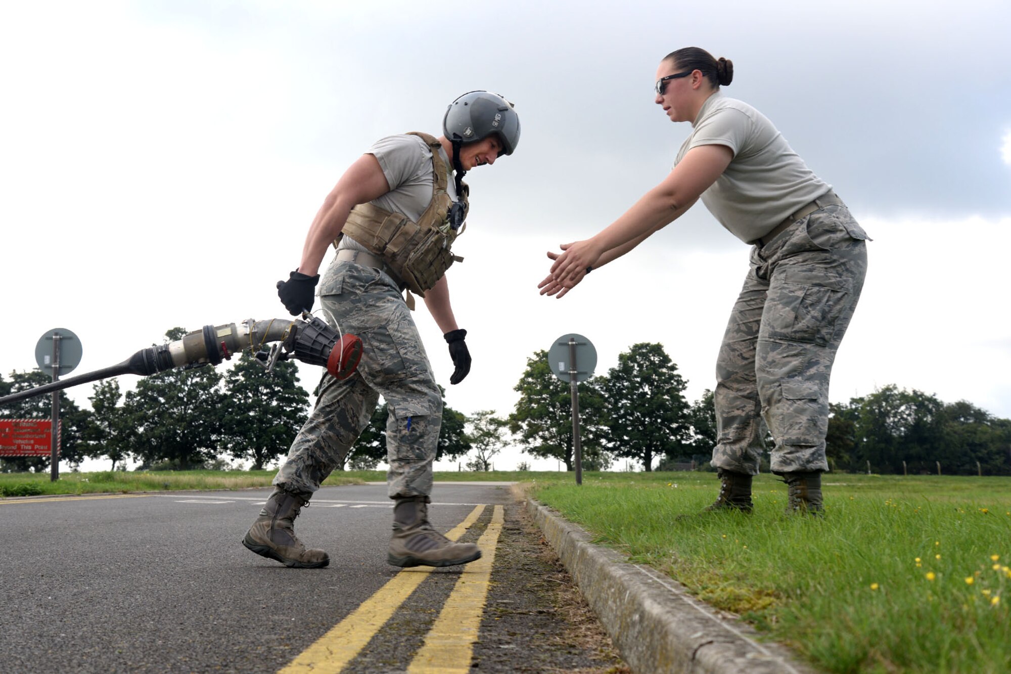 U.S. Air Force Senior Airman Kyla Reed, right, 100th Logistics Readiness Squadron preventative maintenance technician, encourages U.S. Air Force Staff Sgt. Brian Nichols, 100th LRS fuels service center controller, to complete a portion of tryouts for the Forward Area Refueling Point team Sept. 3, 2015, on RAF Mildenhall, England. Current members of the FARP team ran alongside and encouraged Airmen as they completed each portion of the tryouts. Utilized mostly in potentially hazardous areas, a FARP is the process of refueling aircraft on the ground from another parked aircraft. (U.S. Air Force photo by Senior Airman Kate Thornton/Released)