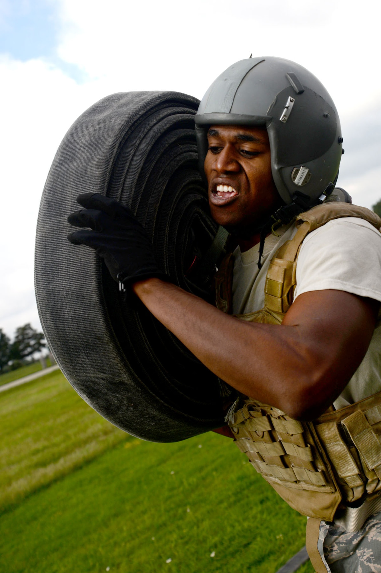 U.S. Air Force Airman 1st Class Joshua Sledge, 100th Logistics Readiness Squadron mobile distribution operator, carries a hose during tryouts for the Forward Area Refueling Point team Sept. 3, 2015, on RAF Mildenhall, England. The rigorous tryouts were designed to test Airmen for a worst-case scenario when performing FARP duties to ensure they could handle tasks under stress and in potentially dangerous areas. Utilized mostly in potentially hazardous areas, a FARP is the process of refueling aircraft on the ground from another parked aircraft. (U.S. Air Force photo by Senior Airman Kate Thornton/Released)