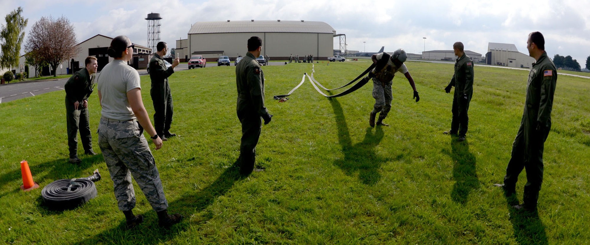Current members of the 100th Logistics Readiness Squadron Forward Area Refueling Point team encourage U.S. Air Force Airman 1st Class Joshua Sledge, 100th LRS mobile distribution operator, as he pulls a fuel hose during FARP team tryouts Sept. 3, 2015, on RAF Mildenhall, England. Tryouts consisted of pulling the hose 300 feet, returning to the starting position; carrying a five-gallon water can, 20-pound fire extinguisher and a squeegee to the end of the hose; then carrying a 85-pound rolled up hose back to the beginning all while being timed. Utilized mostly in potentially hazardous areas, a FARP is the process of refueling aircraft on the ground from another parked aircraft. (U.S. Air Force photo by Senior Airman Kate Thornton/Released)
