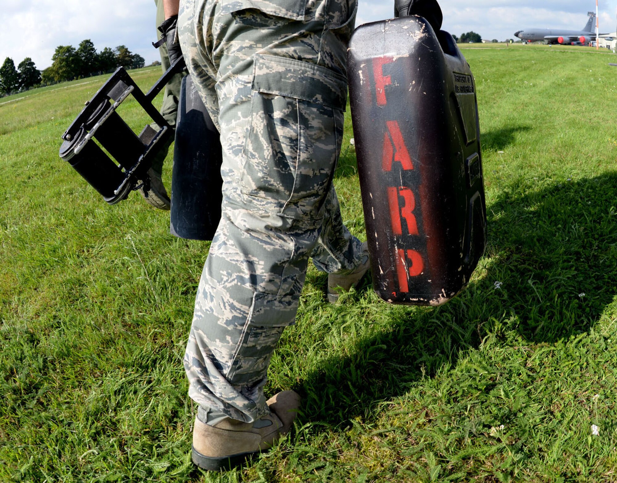 U.S. Air Force Tech. Sgt. Jeffrey Wright, 100th Logistics Readiness Squadron NCO in charge of the fuels information service center, carries equipment during tryouts for the Forward Area Refueling Point team Sept. 3, 2015, on RAF Mildenhall, England. Tryouts consisted of pulling a fuel hose 300 feet, returning to the starting position; carrying a five-gallon water can, 20-pound fire extinguisher and a squeegee to the end of the hose; then carrying a 85-pound rolled up hose back to the beginning all while being timed. Utilized mostly in potentially hazardous areas, a FARP is the process of refueling aircraft on the ground from another parked aircraft. (U.S. Air Force photo by Senior Airman Kate Thornton/Released)