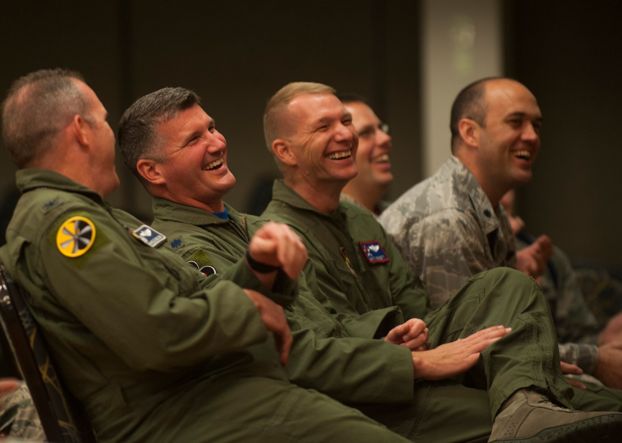 Team Little Rock leadership share a laugh during the comedic traffic safety show in Hangar 1080 Aug. 28, 2015, on Little Rock Air Force Base, Ark. Steve Verret is the comedian who discussed real safety situations and related them to the audience through humor. (U.S. Air Force photo by Senior Airman Scott Poe)