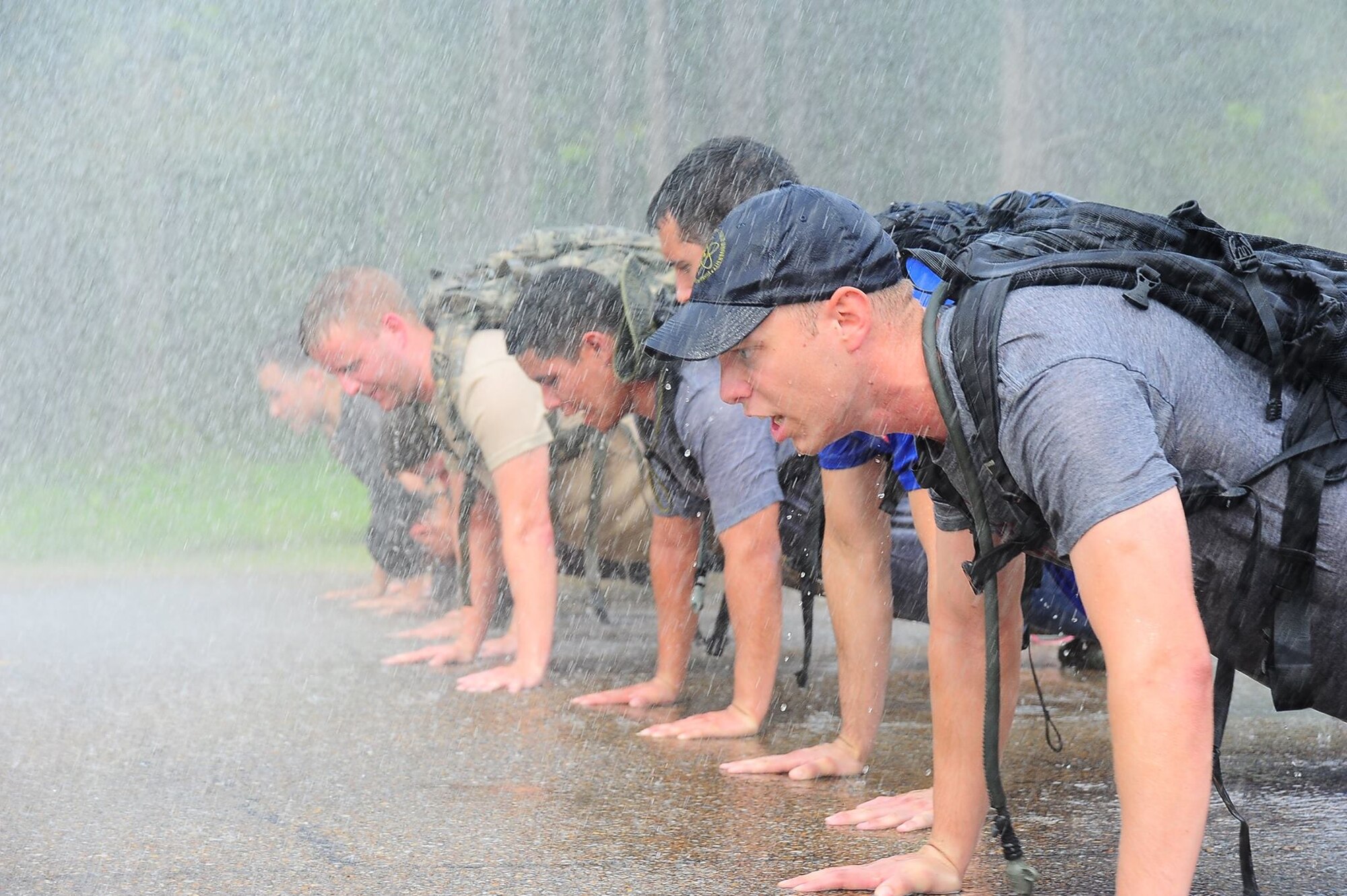 Participants in the Team Cohesion Challenge do push-ups while being dowsed by a fire hydrant Sept. 2 on Columbus Air Force Base, Mississippi. More than 30 Team BLAZE members participated in the Team Cohesion Challenge. (U.S. Air Force photo/Airman 1st Class Daniel Lile)