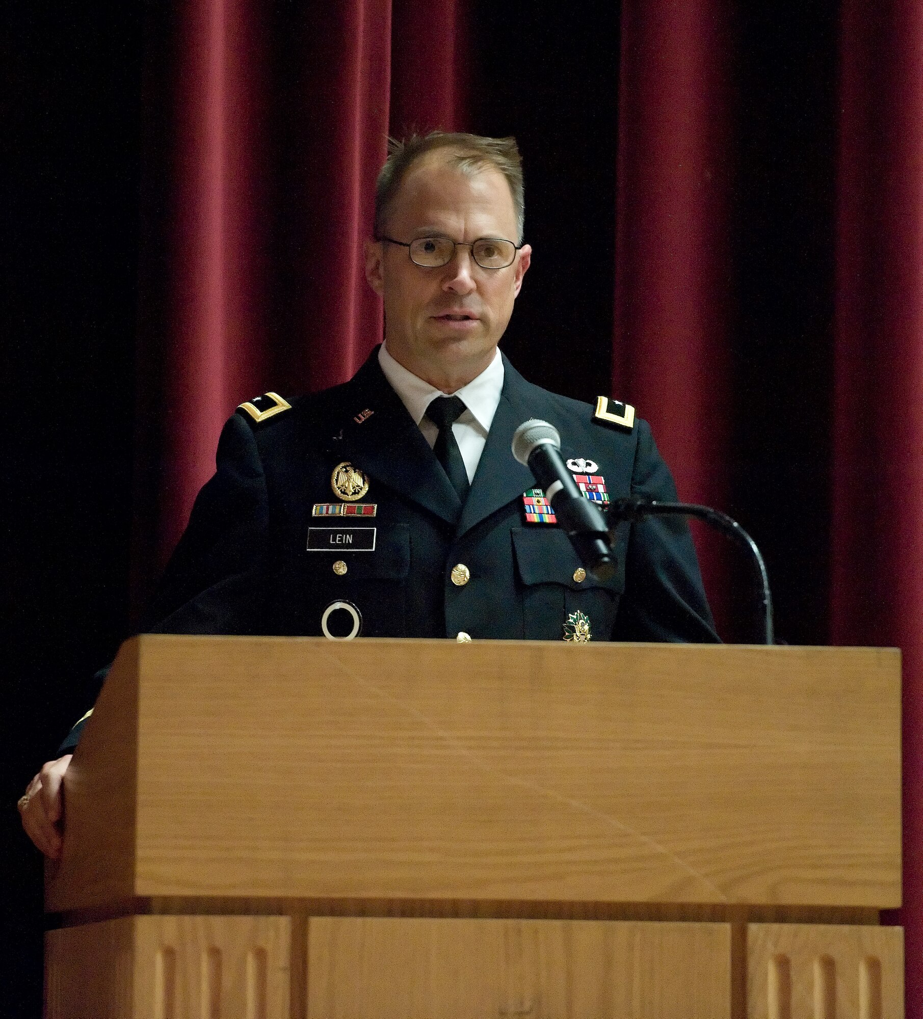 Maj. Gen. Brian Lein, commanding general, U.S. Army Medical Research and Material Command, Fort Detrick, Maryland, speaks to distinguished guests, Armed Forces Medical Examiner personnel and members of Team Dover in attendance during a transition and flag casing ceremony Aug. 31, 2015, at the Base Theater on Dover Air Force Base, Del. Approximately 250 military, civil service and contractor personnel assigned to AFMES will now fall under the Department of Defense as a result of the transition. (U.S. Air Force photo/Roland Balik)