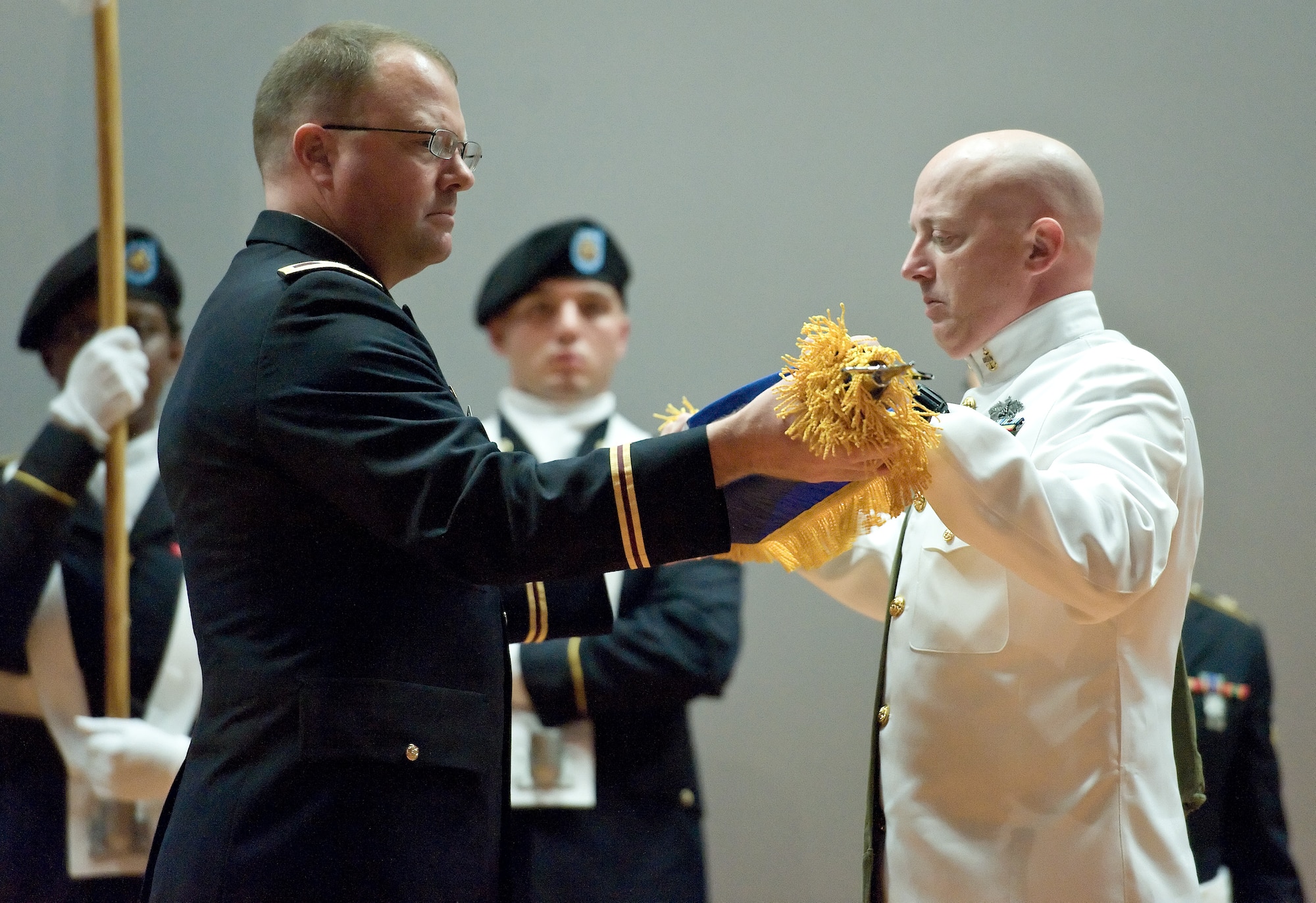 Col. Ladd Tremaine, director, Armed Forces Medical Examiner, left, and U.S.Navy Senior Chief Petty Officer Stanley Travioli, AFMES senior enlisted advisor, right, case the AFMES colors during a ceremony Aug. 31, 2015, at the Base Theater on Dover Air Force Base, Del. By the order of the Surgeon General of the U.S. Army, AFMES transitioned from the U.S. Army Medical Research and Material Command to the Defense Health Agency. (U.S. Air Force photo/Roland Balik)