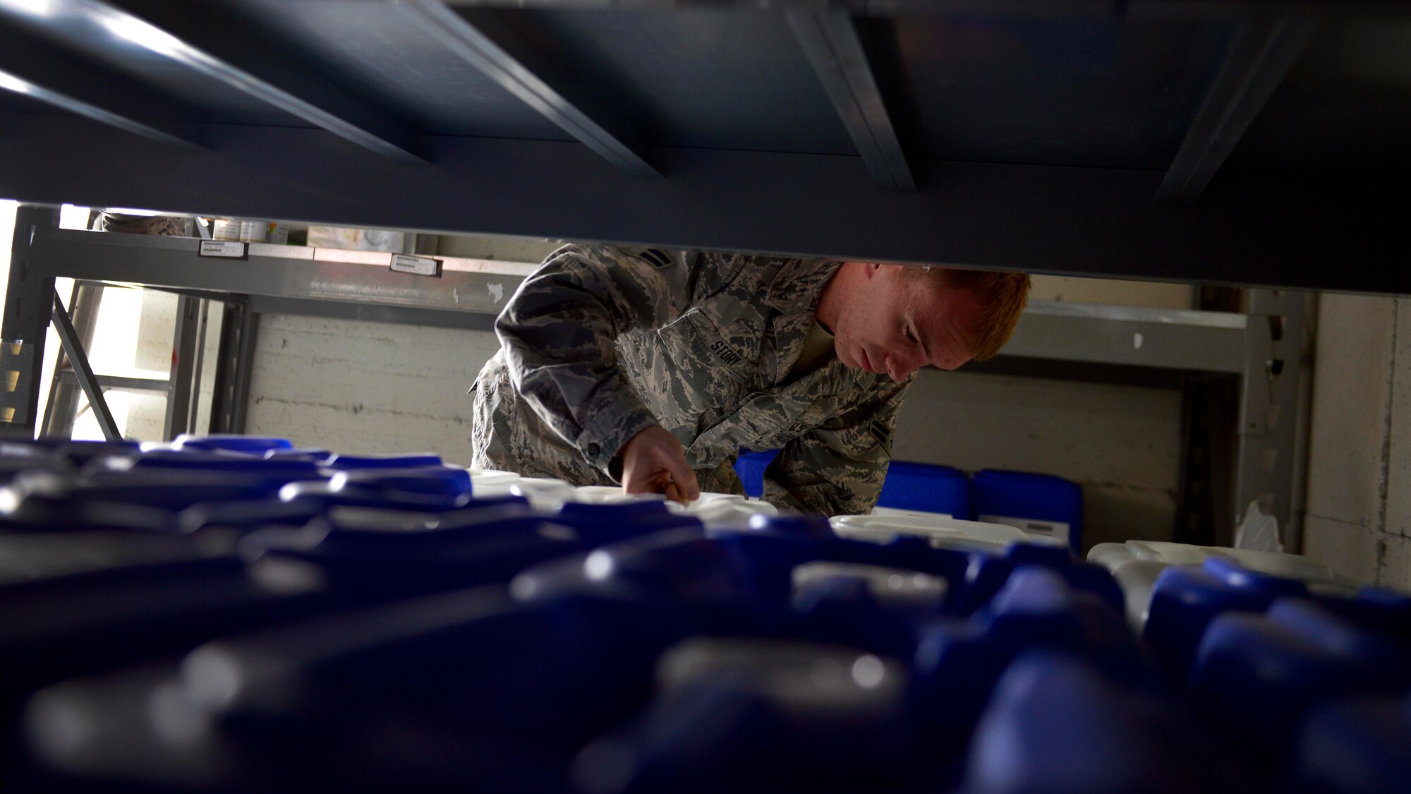 U.S. Air Force Airman 1st Class Kevin Story, 31st Logistics Readiness Squadron Hazardous Material Supply journeyman, places a container of de-mineralized water into HAZMAT warehouse, Sept. 2, 2015, at Aviano Air Base, Italy. Corrosive and flammable materials are stored in secure HAZMAT warehouses until they are picked up. (U.S. Air Force photo by Airman 1st Class Cary Smith/Released)