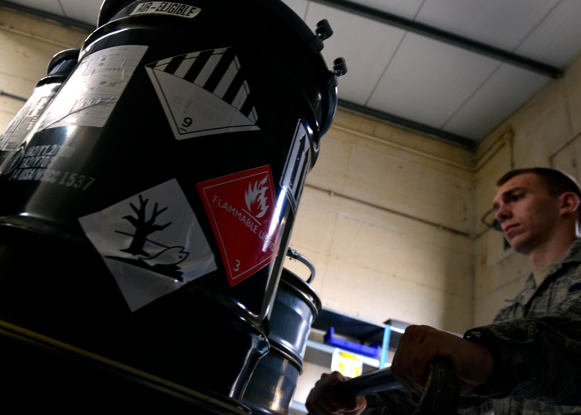 U.S. Air Force Airman 1st Class Kevin Story, 31st Logistics Readiness Squadron Hazardous Material Supply journeyman, moves shipping barrels, Sept. 2, 2015, at Aviano Air Base, Italy. Corrosive materials are shipped to Aviano in protective containers to prevent leakage and then re-used by the 31st LRS Traffic Management office for outbound HAZMAT. (U.S. Air Force photo by Airman 1st Class Cary Smith/Released)