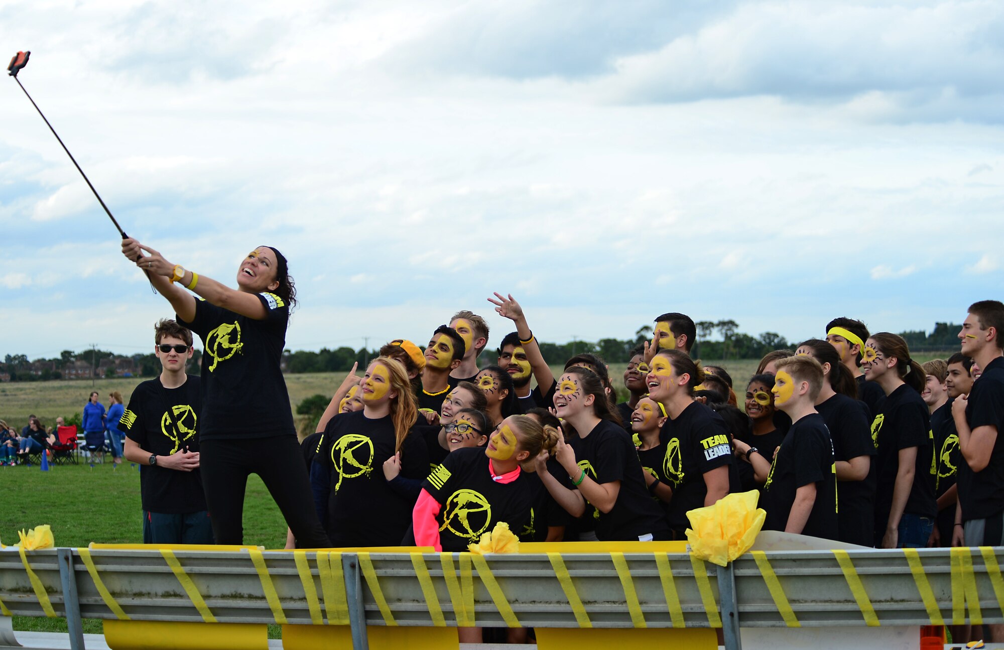 A team leader takes a group photo before a competitive field game at Royal Air Force Lakenheath, England, Aug. 3, 2015. An event involving physically challenging games, known as “The RACE,” is designed to help students interact and make new friends before the start of the school year. (U.S. Air Force photo by Senior Airman Erin O’Shea/Released)