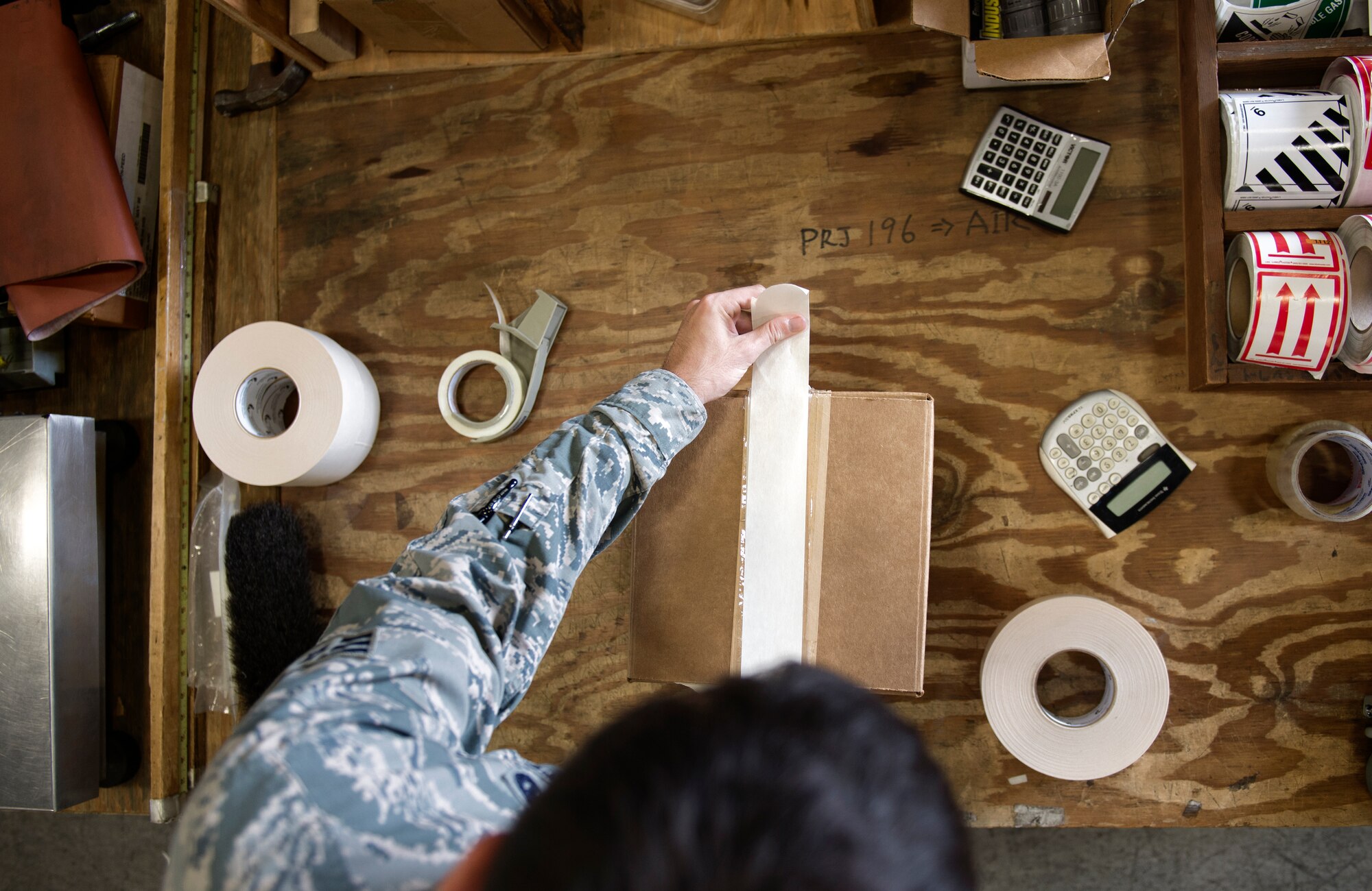 Senior Airman Brandon Walsh, 374th Logistics Readiness Squadron outbound specialist, applies packaging tape to a box at Yokota Air Base, Japan, Sept. 2, 2015. The 374 traffic management office outbound section packages, processes and ships cargo for Yokota personnel. (U.S. Air Force photo by Airman 1st Class Delano Scott/Released)