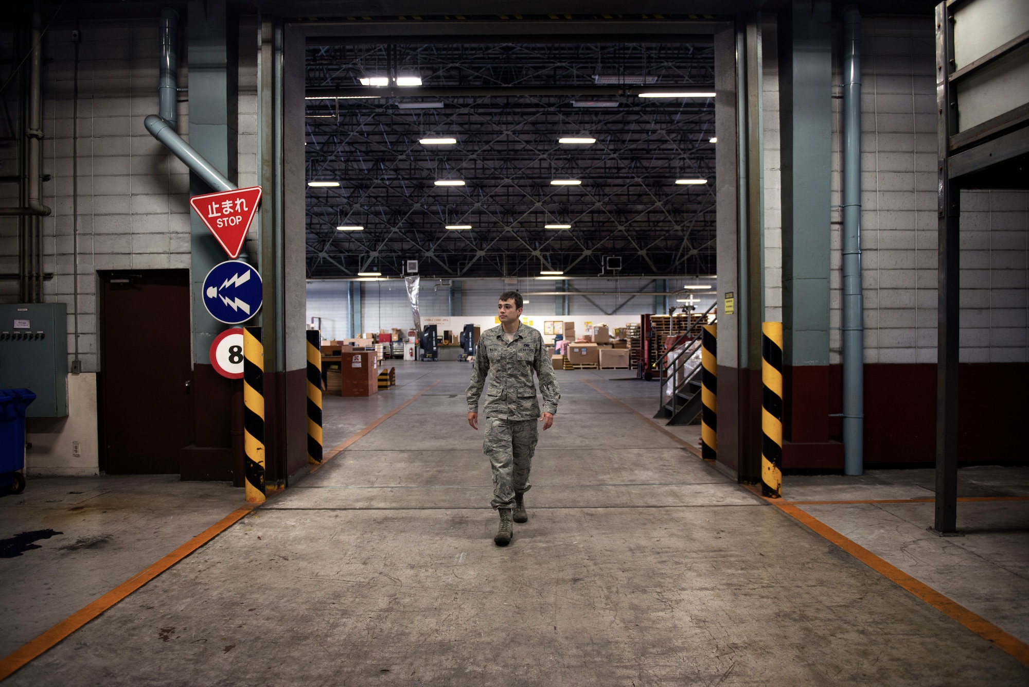 Senior Airman Brandon Walsh, 374th Logistics Readiness Squadron outbound specialist, walks towards the packaging section of a warehouse at Yokota Air Base, Japan, Sept. 2, 2015. The 374 LRS Traffic Management Office consists of many different sections including packaging and crating, inbound and outbound cargo, household goods, passenger travel, and quality assurance.  (U.S. Air Force photo by Airman 1st Class Delano Scott/Released)
