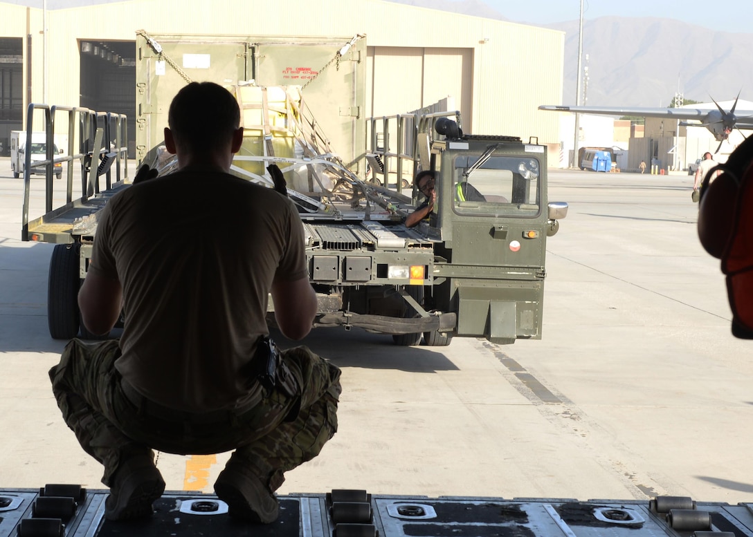 U.S. Air Force Staff Sgt. Casey Strauss, 774th Expeditionary Airlift Squadron C-130J Super Hercules aircraft loadmaster, directs a truck as he prepares to load cargo Aug. 28, 2015 at Bagram Airfield, Afghanistan. Strauss, who is a part of the ‘1000s of Hands’ project, is responsible for on-loading and offloading mission essential goods throughout Afghanistan as well as ensuring the safety of passengers and crew members during flight. (U.S. Air Force photo by Senior Airman Cierra Presentado/Released)