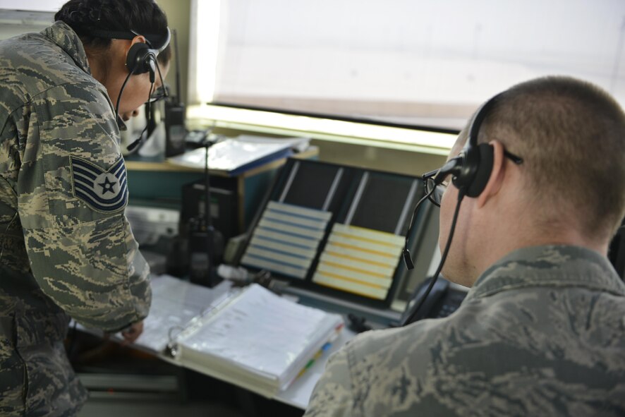 Tech. Sgt. Kelena Hendricks and Senior Airman Dustin Brannan, 379th Expeditionary Operations Support Squadron air traffic control, look over base specific instructions for landing aircraft September 2, 2015 at Al Udeid Air Base, Qatar. While on shift, airmen of the 379th EOSS ATC review airfield operation regulations to stay current and keep coalition forces safe as aircraft taxi, take off and land. (U.S. Air Force photo/Staff Sgt. Alexandre Montes)