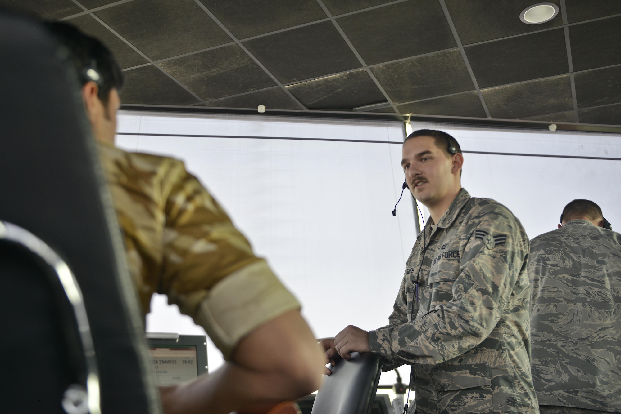 Senior Airman Nicholas Randolph, 379th Expeditionary Operations Support Squadron air traffic controller, coordinates with Qatari military ATC before advising aircraft of the takeoff line-up September 2, 2015 at Al Udeid Air Base, Qatar. Airmen of the 379th EOSS ATC work closely with Qatari military ATC in conducting airfield operations to support coalition forces deployed here in support of Operation Inherent Resolve and Operation Freedom’s Sentinel. (U.S. Air Force photo/Staff Sgt. Alexandre Montes)