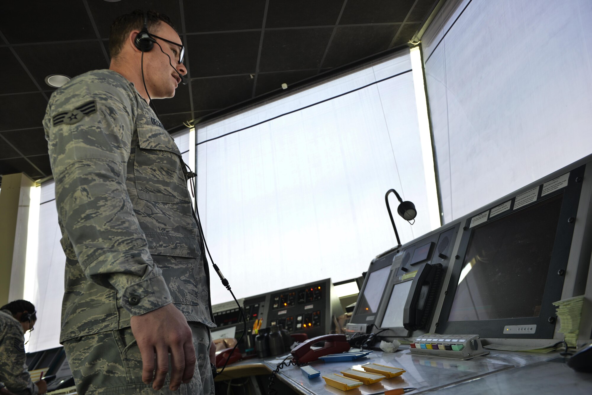 Senior Airman Deuey Uecker, 379th Expeditionary Operations Support Squadron air traffic controller, informs aircrew aboard a C-130J Super Hercules on parking procedures September 2, 2015 at Al Udeid Air Base, Qatar. U.S. Air Force air traffic controllers deployed to Al Udeid Air Base remain in constant contact with coalition aircraft departing and entering the base’s airspace while working side-by-side with Qatari military ATC. (U.S. Air Force photo/Staff Sgt. Alexandre Montes)