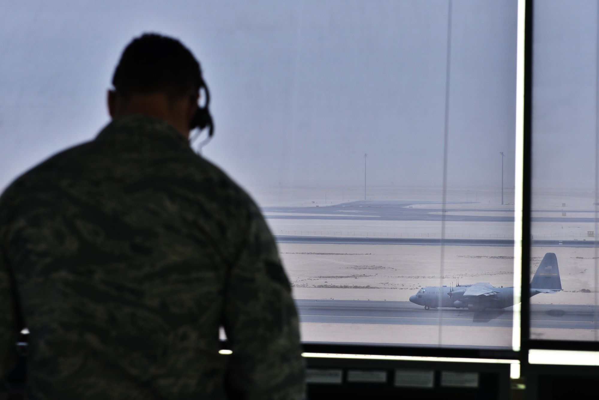 Senior Airman Deuey Uecker, 379th Expeditionary Operations Support Squadron air traffic controller, informs aircrews aboard a C-130J Super Hercules on parking procedures September 2, 2015 at Al Udeid Air Base, Qatar. U.S. Air Force air traffic controllers deployed to Al Udeid Air Base remain in constant contact with coalition aircraft departing and entering the base’s airspace while working side-by-side with Qatari military ATC. (U.S. Air Force photo/Staff Sgt. Alexandre Montes)