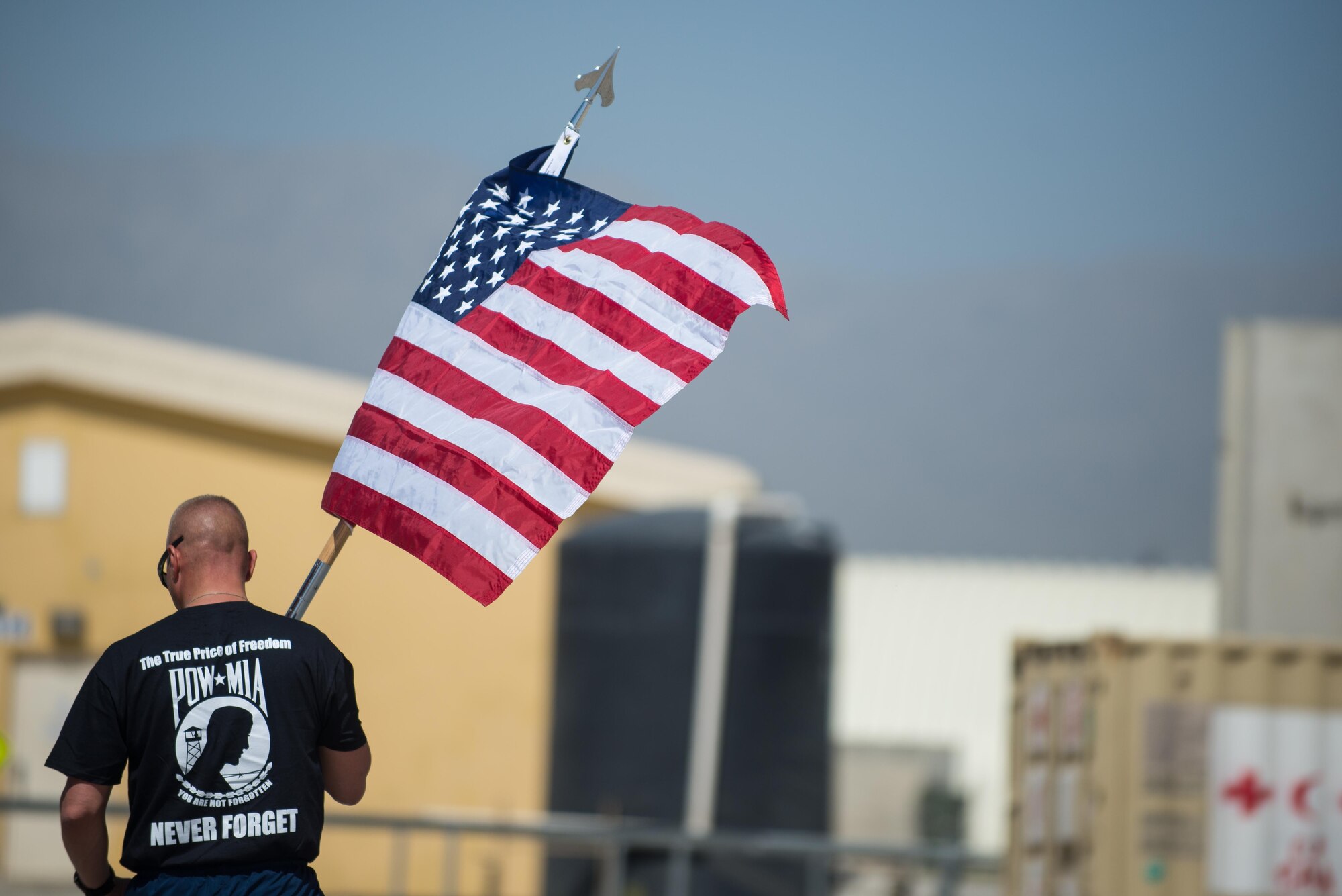 U.S. Air Force Chief Master Sgt. Matt Grengs, 455th Air Expeditionary Wing command chief, carries the U.S. flag during the prisoners of war, missing in action run at Bagram Airfield, Afghanistan, Sept. 3, 2015. For 24 straight hours, BAF Service members kept the POW/MIA flag in constant motion in honor of American prisoners of war and those missing in action. (U.S. Air Force photo by Tech. Sgt. Joseph Swafford/Released)